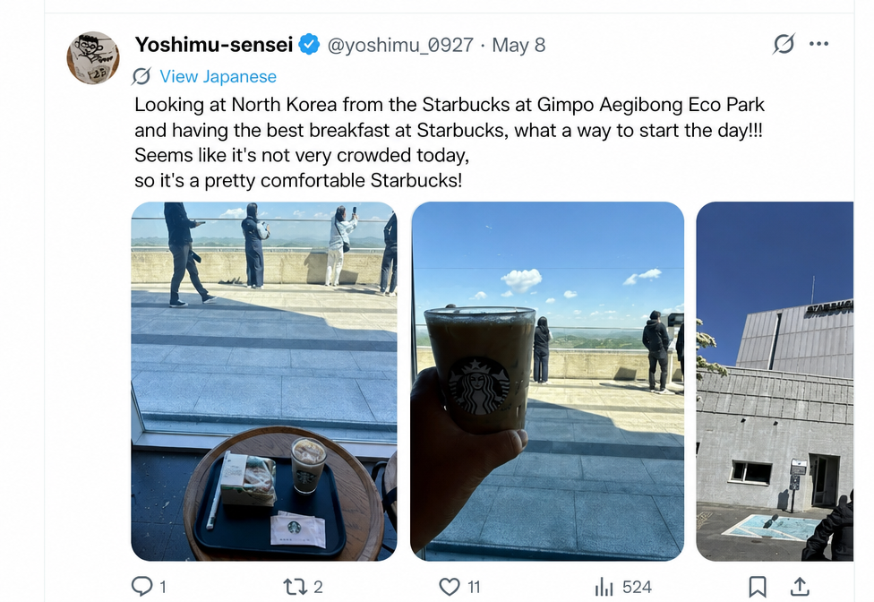 A screenshot of a tweet from a Japanese user holding a coffee by the window inside the Starbucks, looking out at the North Korean landscape.