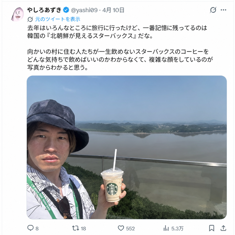 北朝鮮の風景を背景にスターバックスコーヒーを手に持ち、複雑で微妙な表情の自撮りをしている日本人漫画家・やしろあずき氏のツイートのスクリーンショット