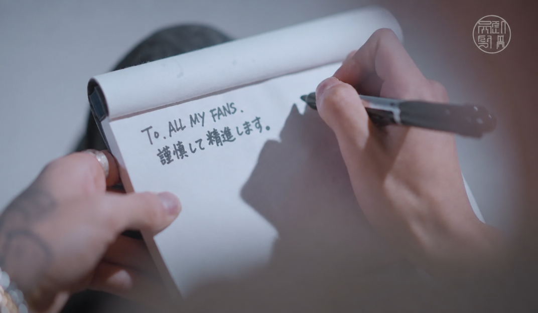 メモ帳に「To. ALL MY FANS. 問題を起こさず、刑期だけ務めます」とペンで書いている手元の様子