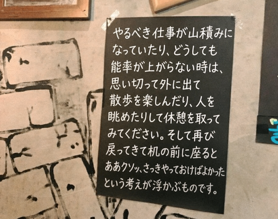 カフェの壁に貼られたメッセージボード。仕事が溜まっている時に思い切って散歩や休憩をして戻ってくると、「あぁ、さっきやっておけばよかった」という考えが浮かぶという現実的なオチが書かれている。