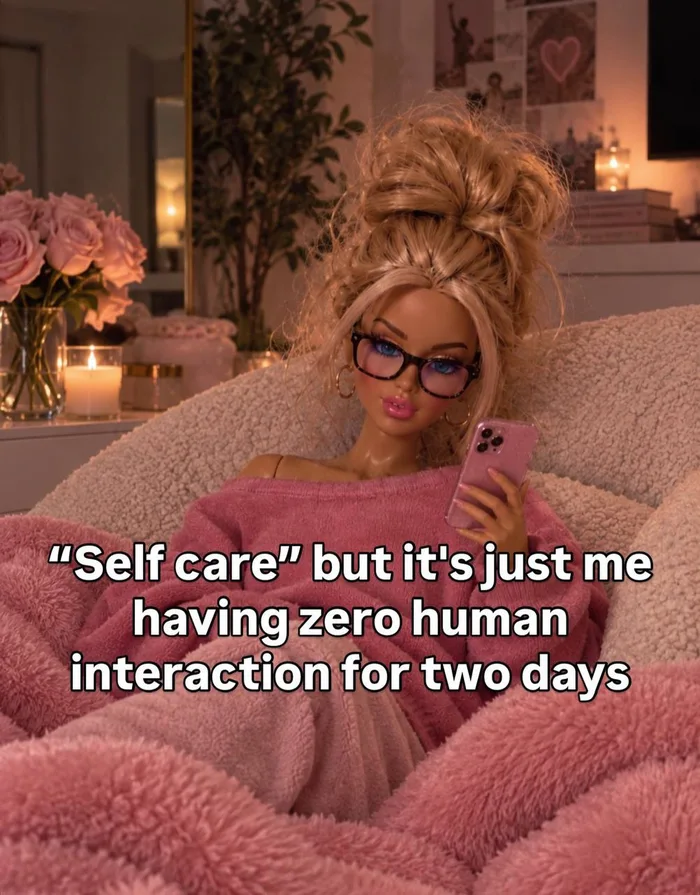 A doll dressed in cozy pink loungewear relaxes in a plush chair holding a smartphone, with overlay text describing self care as having zero human interaction for two days.