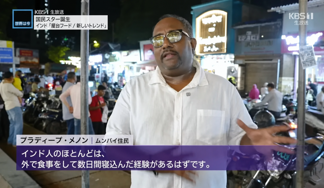 KBS1ニュースの放送画面。ムンバイ住民のプラディープ・メノン氏が、インド人のほとんども外食をして数日間寝込んだ経験があるはずだとインタビューに答えている様子。