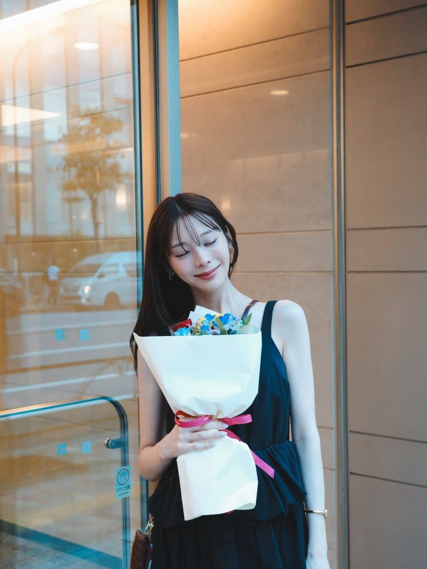 花束を抱えて微笑む女性の姿
