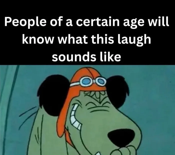 A still of the cartoon dog Muttley wearing an aviator cap and goggles, grinning slyly with his hand over his mouth as if snickering, with caption text above.