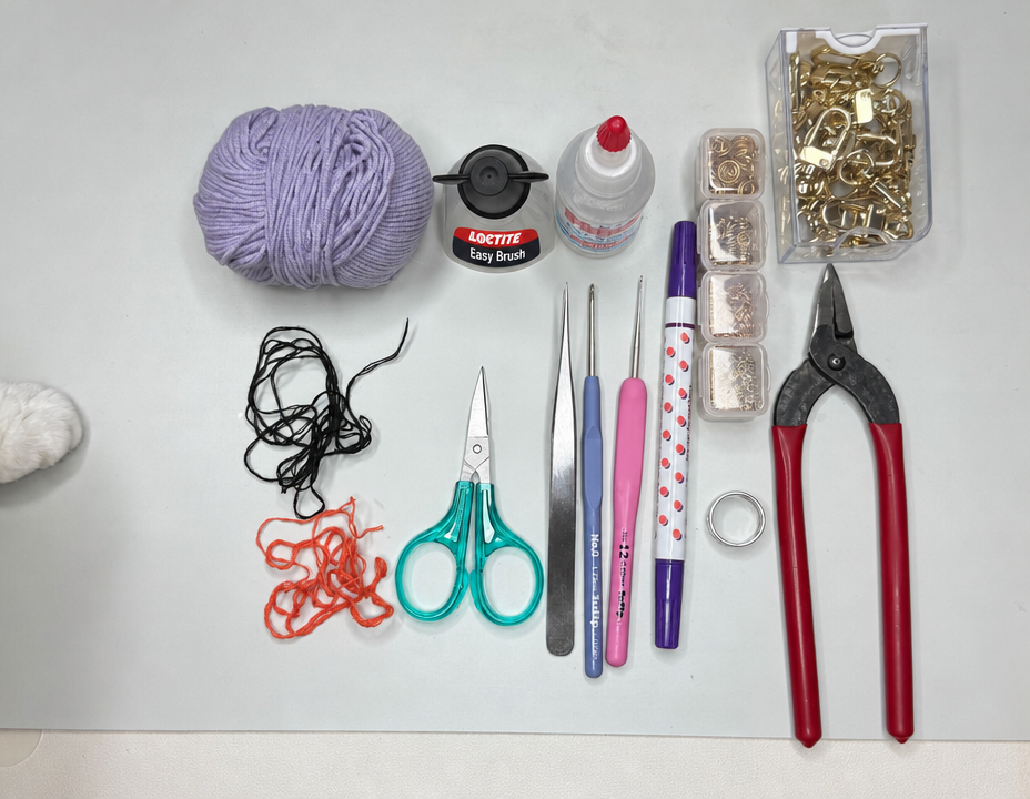 Knitting tools and materials including purple yarn, scissors, a crochet hook, tweezers, a pen, and adhesive.