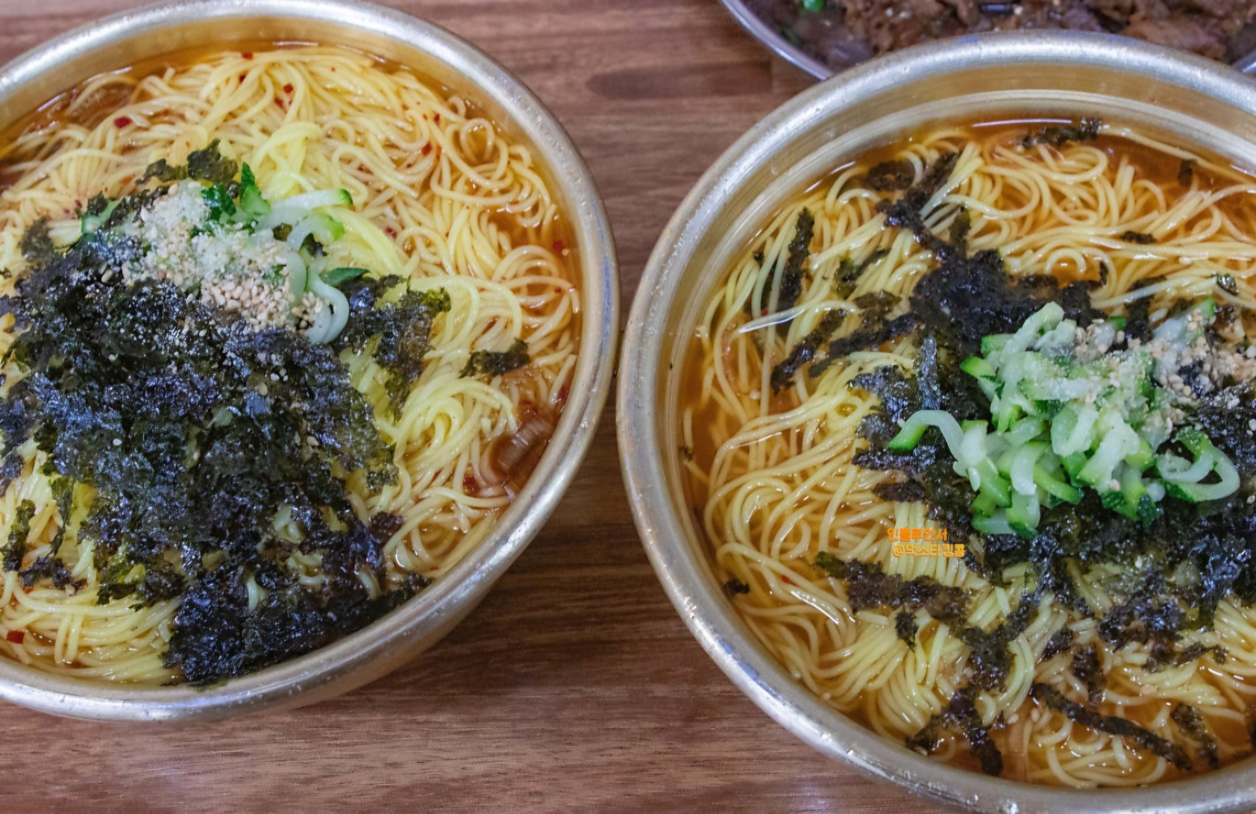 真鍮の器2つにそれぞれ満タンに入った温麺の「大盛り」と「普通」の比較写真。