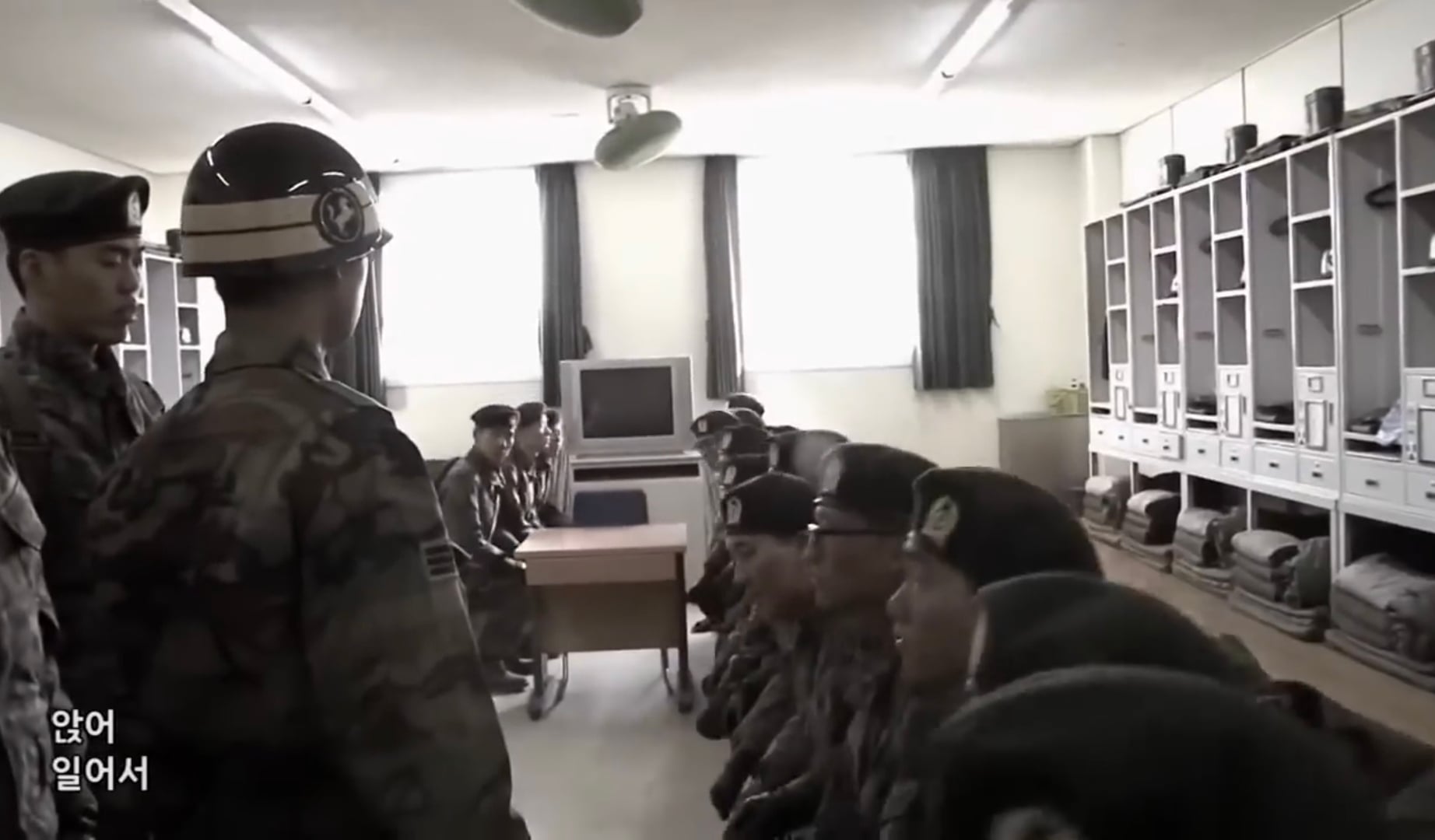 A drill instructor facing a recruit with a stern expression