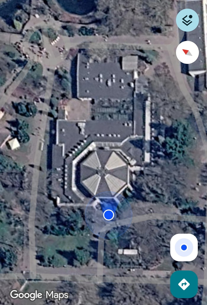Satellite view of a building on Google Maps with a rooftop shaped like the Umbrella Corporation logo.