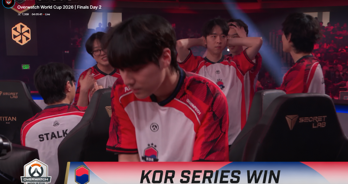 South Korean national team players celebrating and standing up from their gaming chairs after securing victory in the 2026 Overwatch World Cup semi-finals.