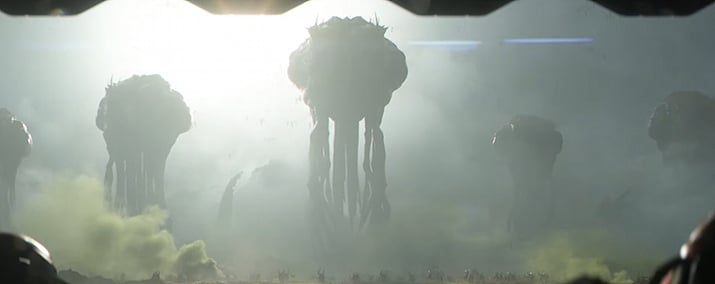 霧の中で巨大な生物塔状のザーグ軍団の構造物が並ぶゲームのシネマティックシーン。
