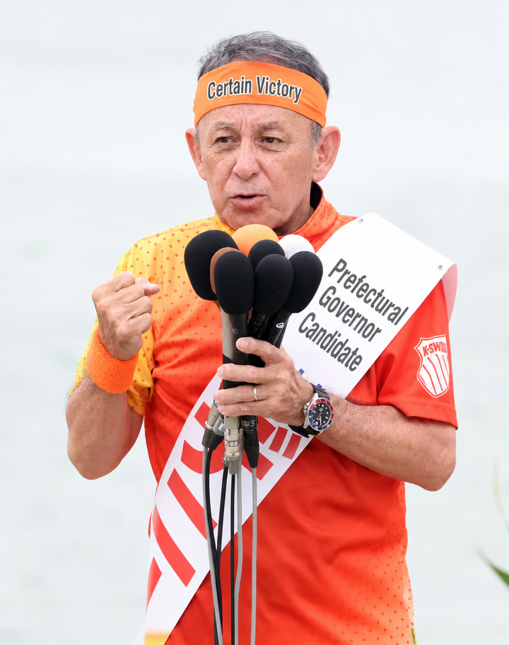 Candidate Denny Tamaki speaking while holding a microphone during the Okinawa gubernatorial campaign