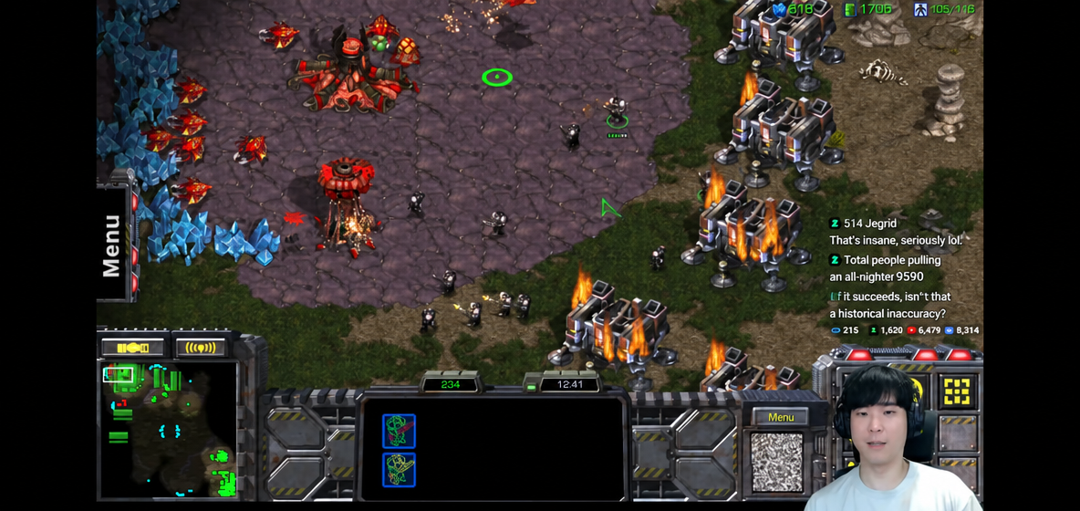 A game screen from a StarCraft broadcast showing Barracks being flown in to take control of the opponent's main base cliff, followed by a Marine attack.