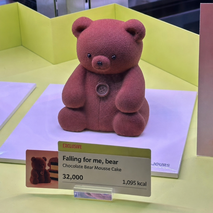 A brown bear-shaped chocolate mousse cake called 'Bear-y In Love With Me' displayed in the Tous Les Jours showcase.