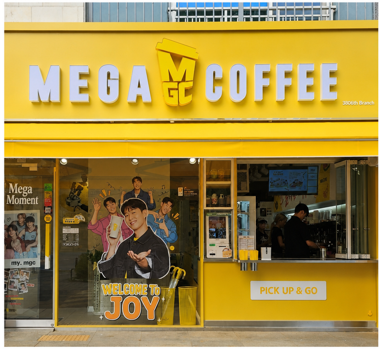 Yellow exterior of a Mega Coffee store with employees busily working to process orders.