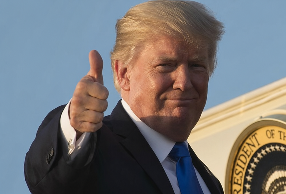 Donald Trump smiling and giving a thumbs-up against the backdrop of the Seal of the President of the United States