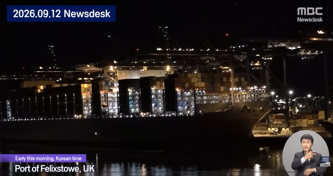 MBC Newsdesk broadcast footage of a large cargo ship docked at the Port of Felixstowe in the UK at night.