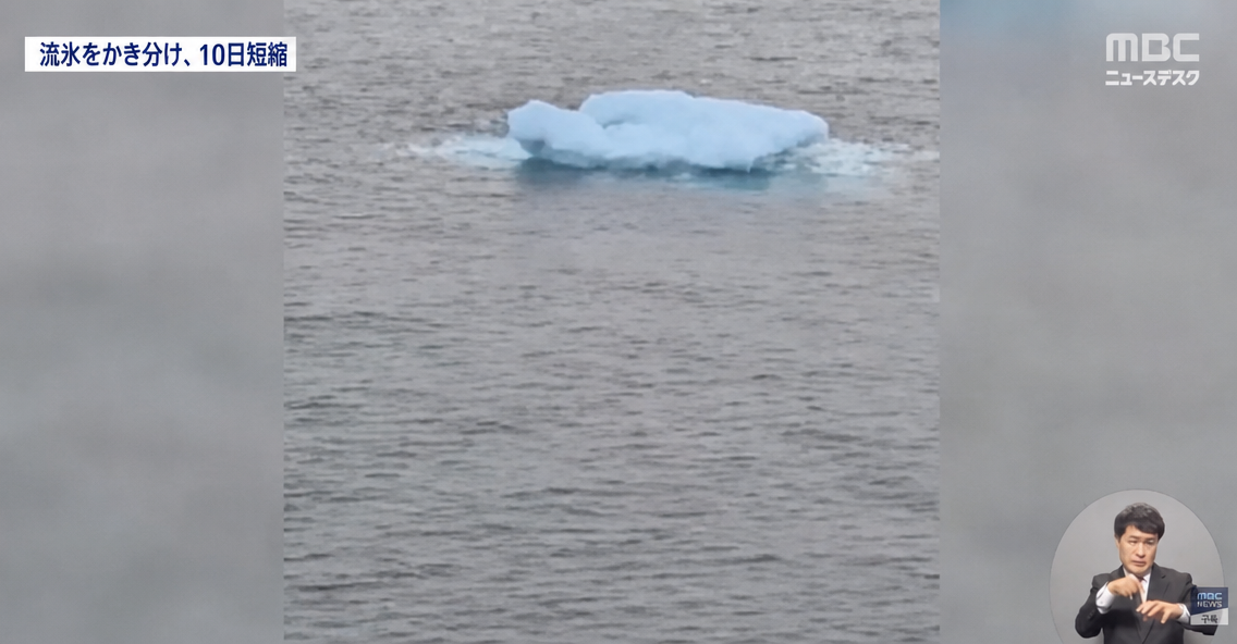 海の真ん中に小さな流氷のかけらがぽつんと1つ浮かんでいる様子の上に「流氷をかき分け10日短縮」の字幕が入ったニュース画面