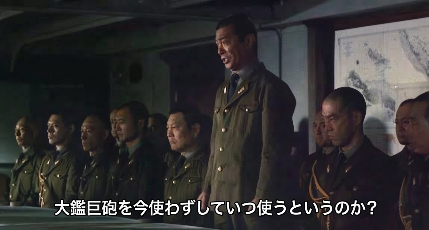 日本軍の軍服を着た軍人たちが集まる会議室で、「大鑑巨砲を今使わずしていつ使うというのか？」という字幕が表示されている映画シーンのスクリーンショット。