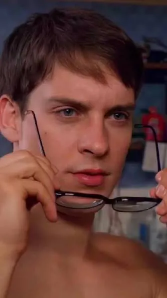 Peter Parker taking off his glasses to take a closer look.