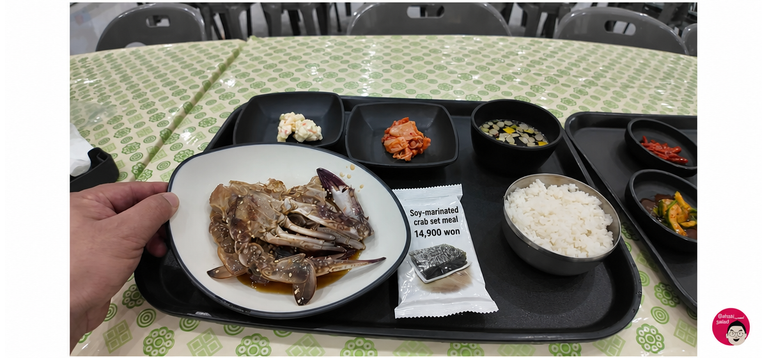 A 14,900 won soy-marinated crab set meal served on a cafeteria tray, including one crab, kimchi, salad, seaweed, rice, and soup.