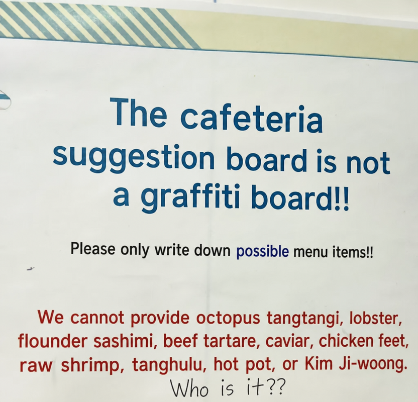 A notice on a school lunch suggestion board. It states it's not a graffiti board and to only write down possible menu items, listing that octopus tangtangi, lobster, flatfish sashimi, yukhoe (beef tartare), caviar, chicken feet, raw shrimp, tanghulu, hot pot, and Kim Ji-woong are difficult to provide, with handwritten graffiti below saying 'Who is it??'.