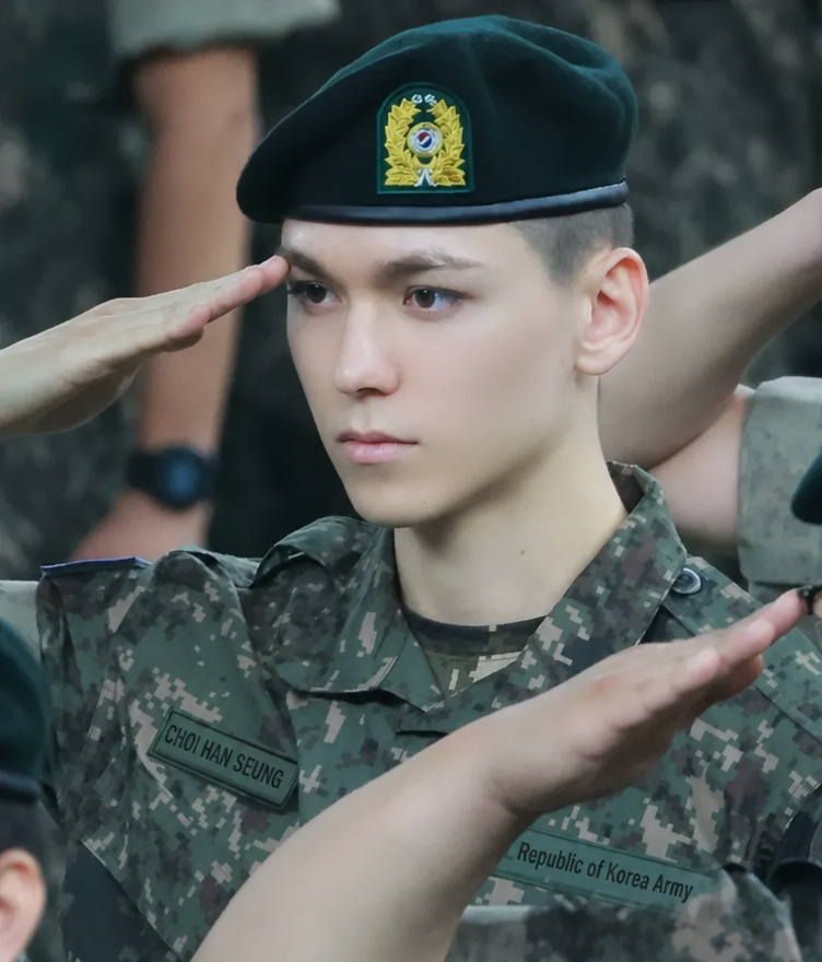 SEVENTEEN's Vernon striking a dignified salute in a military uniform.