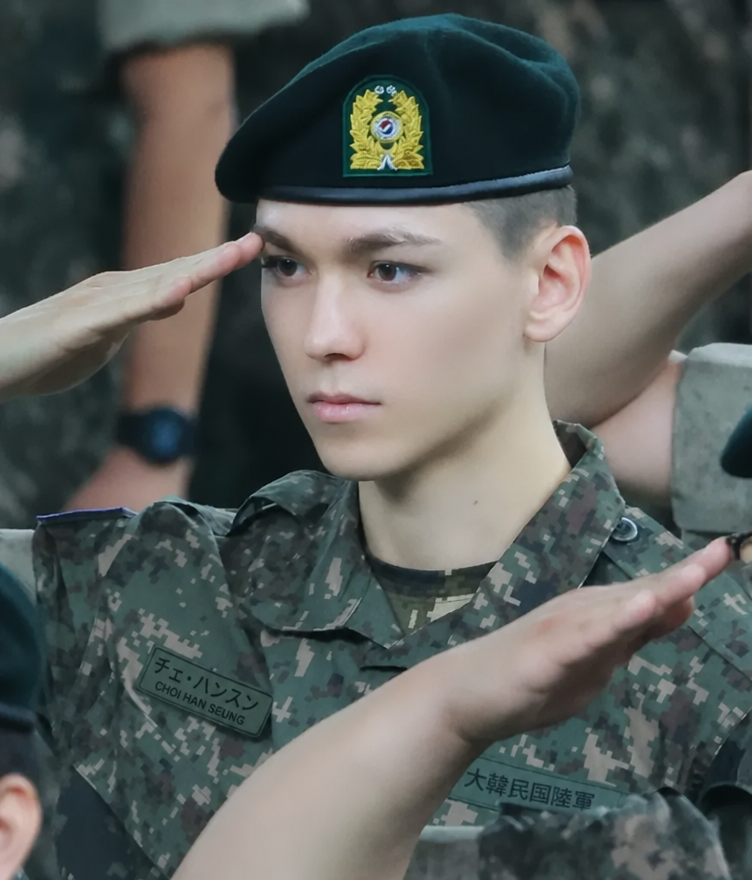 軍服姿で凛々しく敬礼のポーズをとるSEVENTEENバーノンの姿。