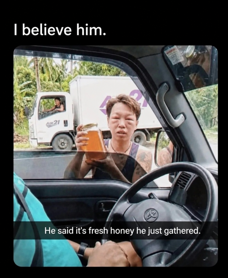 A man with a severely swollen face from bee stings holding up a jar of honey outside a car window.