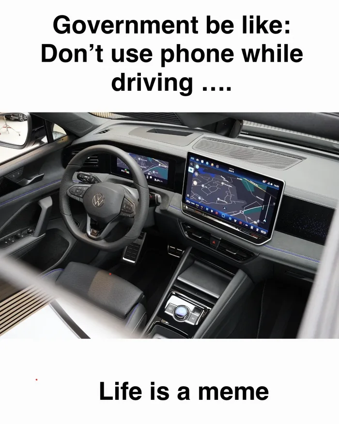 Car interior with a giant infotainment screen and digital dashboard, paired with text commenting on phone driving laws.