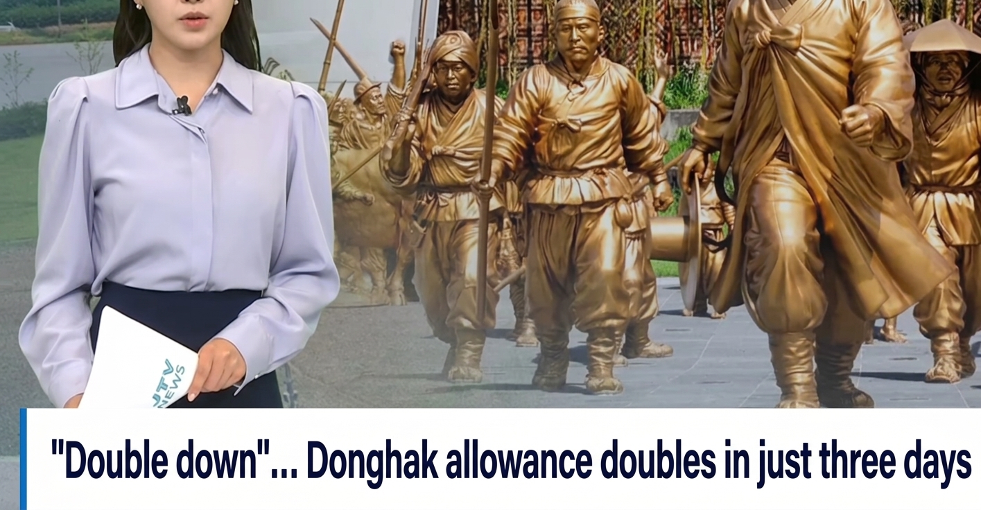 A news broadcast showing an anchor with a monument commemorating the Donghak Peasant Revolution in the background, captioned: '"Double down"... Donghak allowance doubles in just three days.'