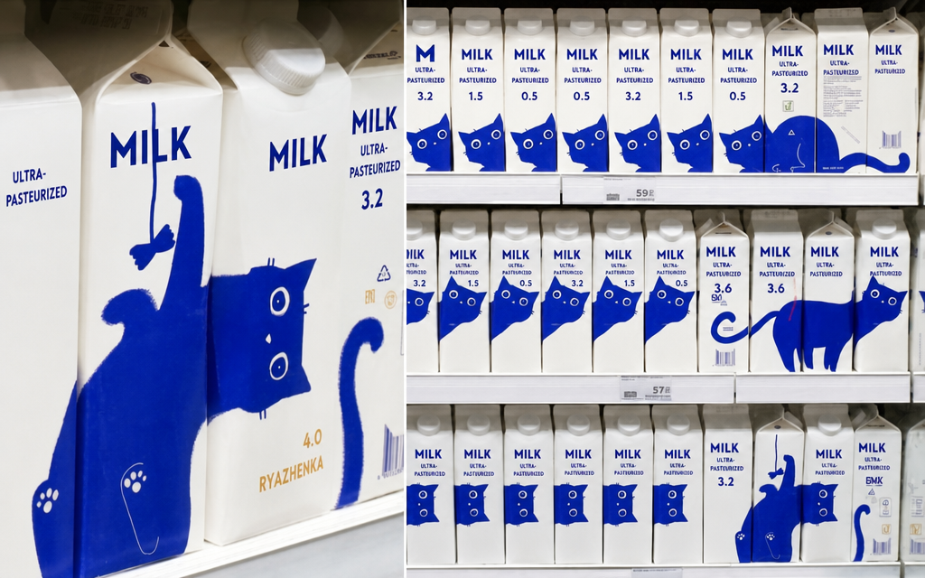 White milk cartons with blue cat illustrations displayed on a Russian supermarket shelf. It's a packaging design where placing several sides of the milk cartons together forms a complete image of a cat standing or playing with a toy.