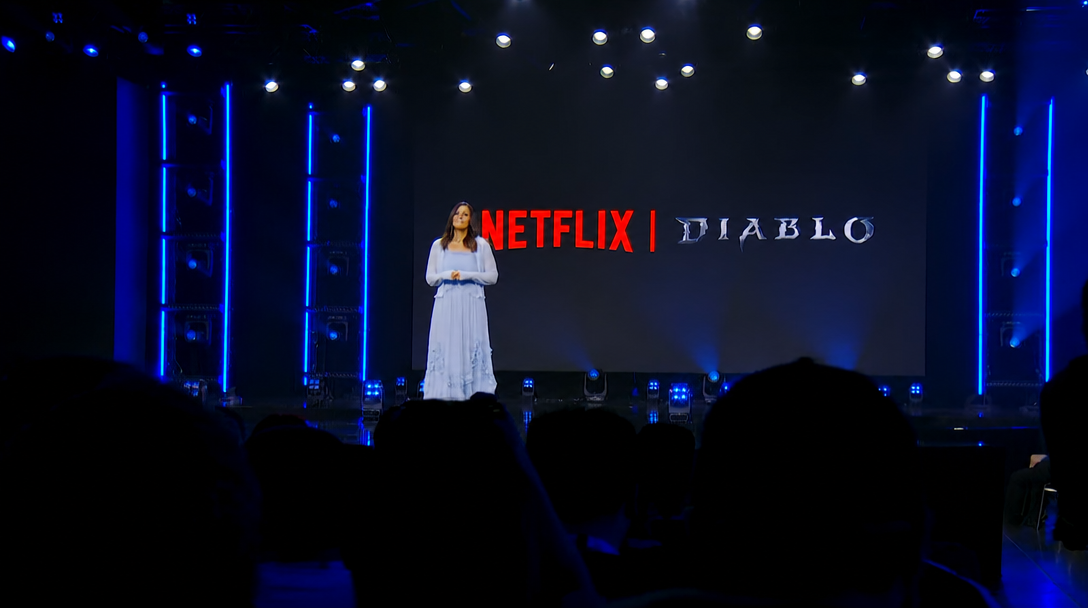 An event stage screen displaying the Netflix and Diablo logos, with a presenter standing on stage