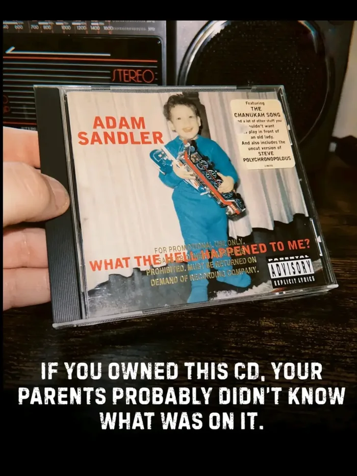 A hand holding a CD jewel case of Adam Sandler's comedy album What the Hell Happened to Me? in front of a stereo, with text below reading: IF YOU OWNED THIS CD, YOUR PARENTS PROBABLY DIDN'T KNOW WHAT WAS ON IT.