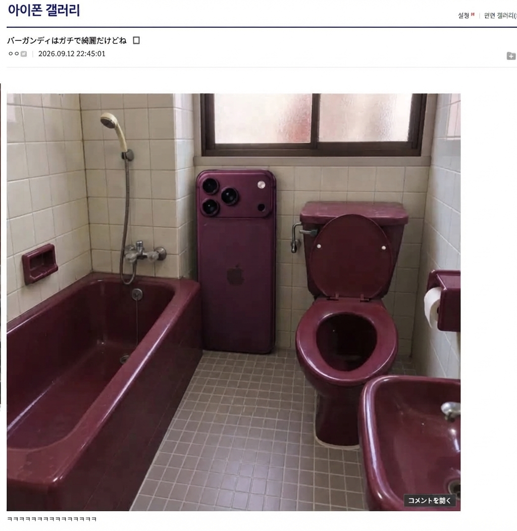 ワインレッド色の浴槽と便器が設置された古い浴室の隅に、同じバーガンディ色の巨大なiPhoneが壁に立てかけられているコラージュ画像。