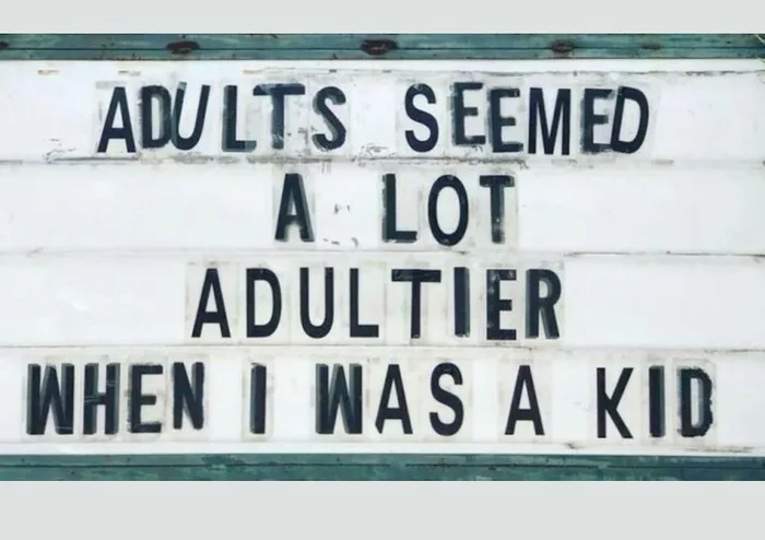 A roadside sign board displaying black lettering that reads: ADULTS SEEMED A LOT ADULTIER WHEN I WAS A KID