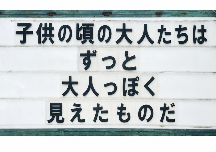 黒い文字で「ADULTS SEEMED A LOT ADULTIER WHEN I WAS A KID（子供の頃の大人たちは、もっと大人っぽく見えたものだ）」と書かれた道端の看板
