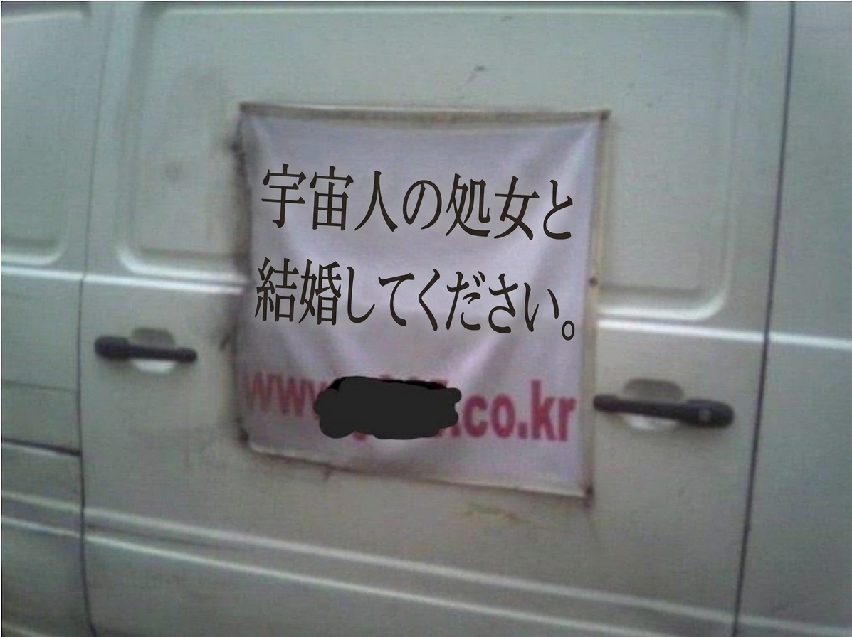白い車両の側面に「宇宙人の処女と結婚してください」という文言と一部隠されたウェブサイトのアドレスが書かれた横断幕が掛けられている写真