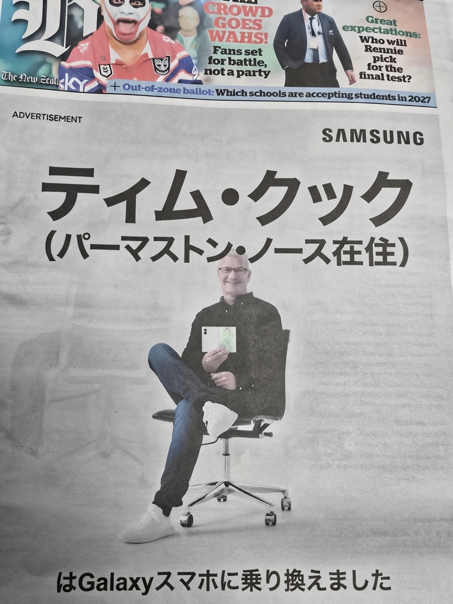 新聞の全面に掲載されたサムスンの広告。椅子に座って折りたたみスマートフォンを持つ男性の写真とともに、「Tim Cook (from Palmerston North) has switched to a Galaxy phone」という文字が大きく書かれている。
