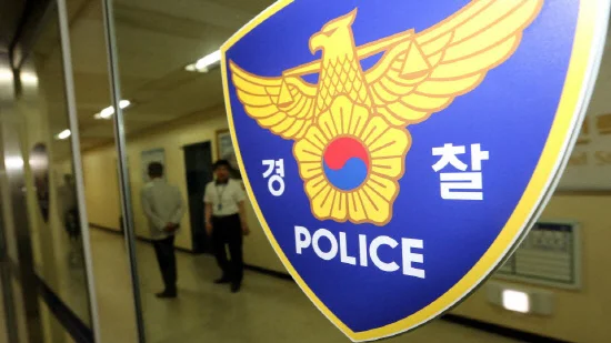 警察のマークがついたガラスドア越しに、廊下を行き交う警察官の姿が見える写真