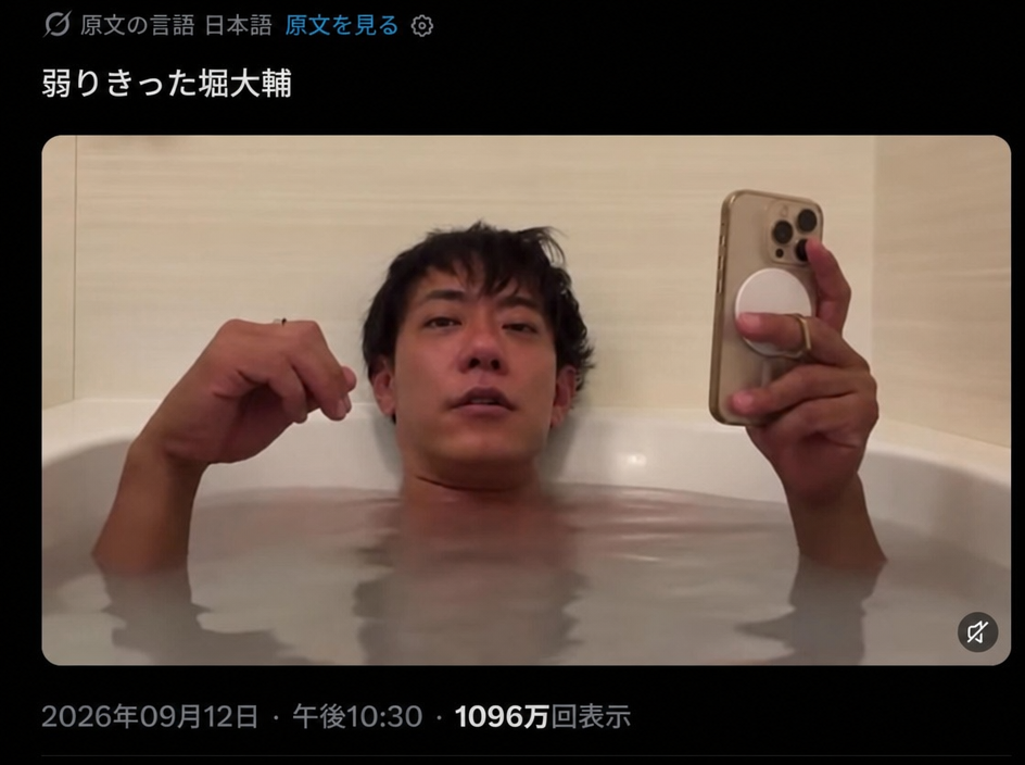浴槽に浸かりながら、疲れ切った表情で自撮りをしている男性の姿。