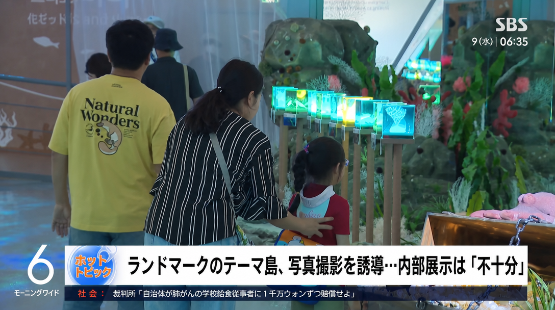 会場内の小さな展示物を見る人々と「内部展示は不十分」という字幕があるSBSニュース画面。
