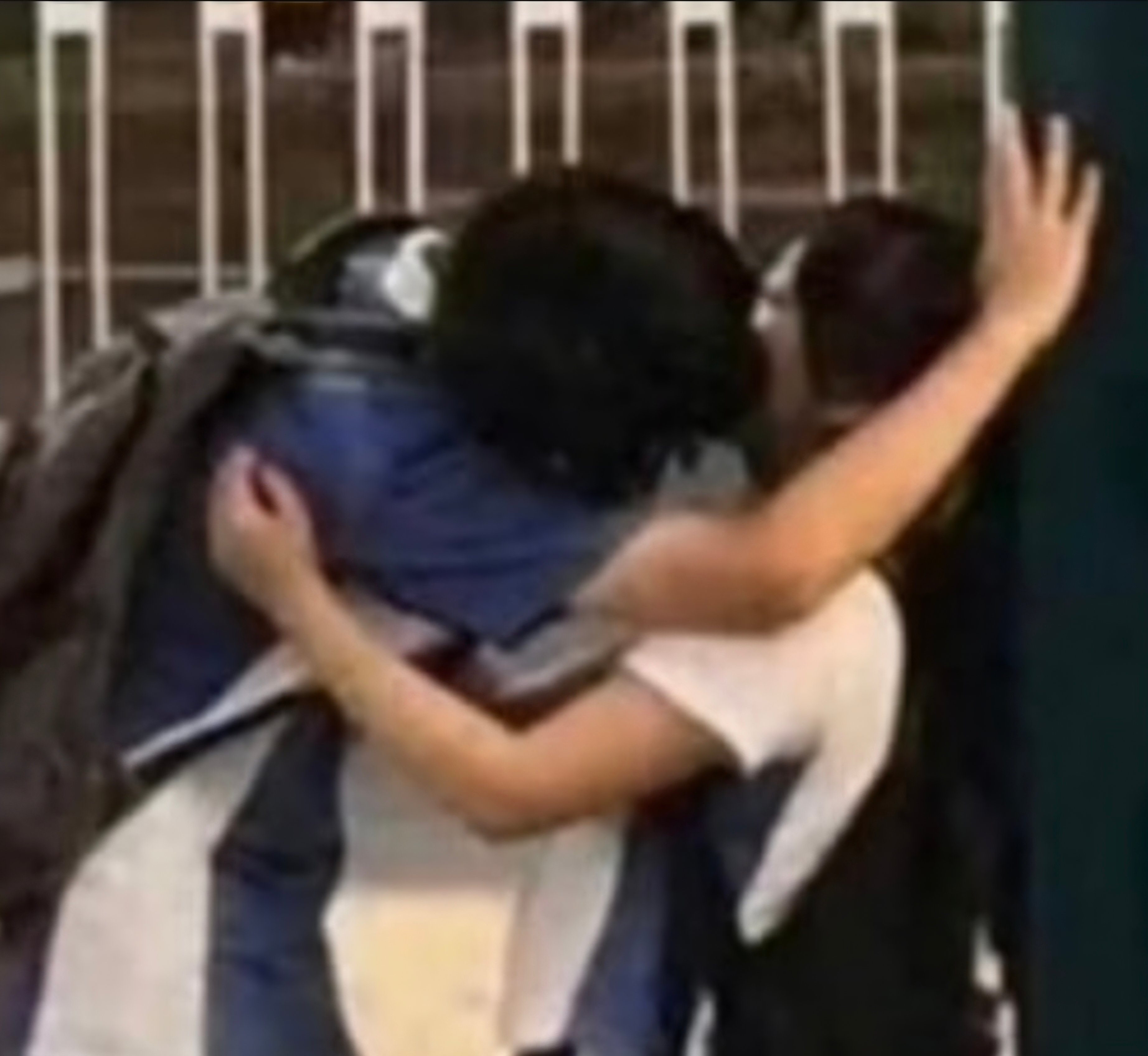 抱き合いながらキスをしている学生二人の上半身