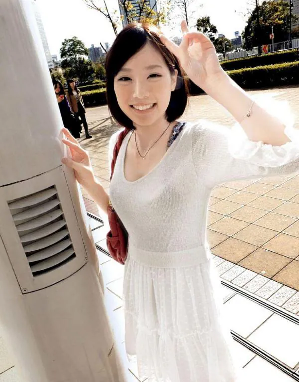 Airi Suzumura wearing a white dress and making a V sign outdoors