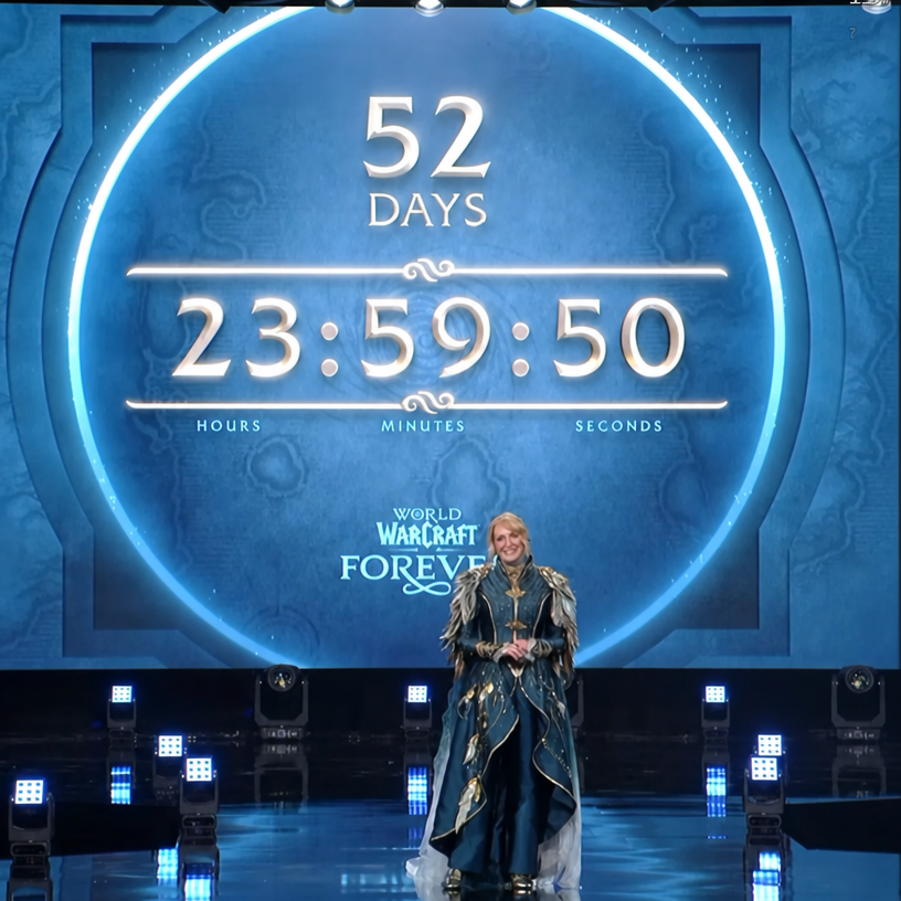 A presenter in blue attire standing on stage in front of a large screen showing a 52-day countdown alongside the 'WORLD OF WARCRAFT FOREVER' logo.