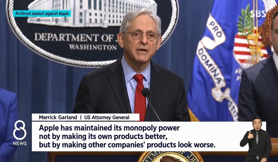 A news broadcast screen showing US Attorney General Merrick Garland announcing the antitrust lawsuit against Apple at a Department of Justice briefing.