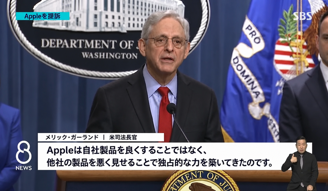 米司法省の会見で、メリック・ガーランド司法長官がAppleに対する反トラスト法（独占禁止法）訴訟に関する立場を発表しているニュース番組の字幕画面。