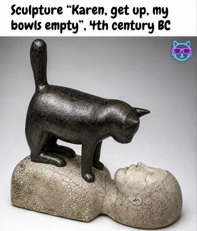 A sculpture showing a cat standing directly on top of a reclining human figure's chest, staring down into their face, with meme text above reading: Sculpture "Karen, get up, my bowls empty", 4th century BC.
