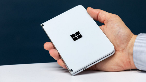 折りたたまれた状態の白いSurface Duoを手の上に載せた様子