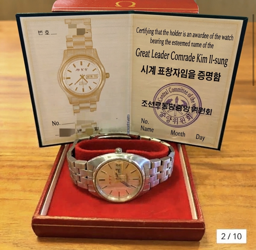 An open certificate and the mounted Omega watch displayed on top of a red Omega watch case