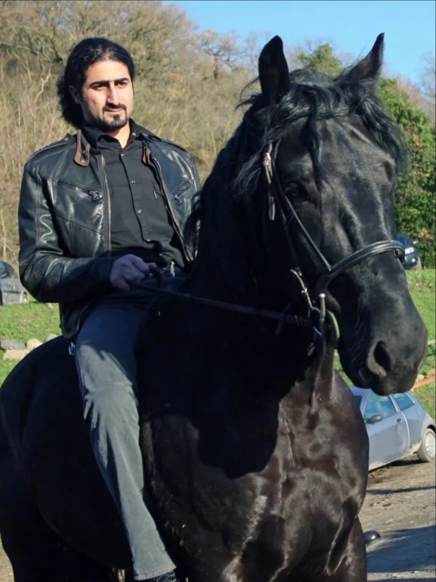 黒い馬に乗っているオマール・ビンラディンの姿
